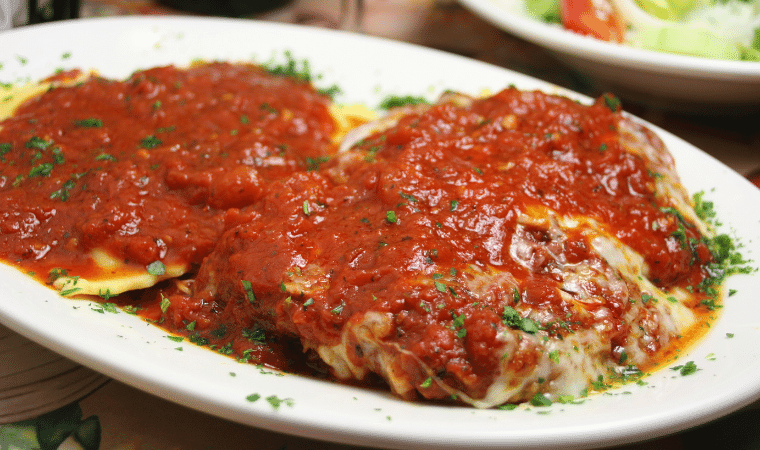 Filé de frango a parmegiana servido em uma travessa de cerâmica branca