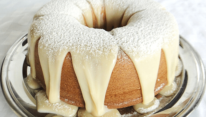 Bolo Fofinho Simples numa bandeja de aço inox com a cobertura Leite Ninho por cima